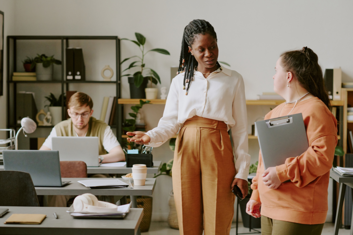 Femme entrepreneur assise à son bureau, réfléchissant avec sérénité sans la pression du Girl Boss mindset.